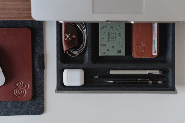 An organised desk drawer containing office supplies 