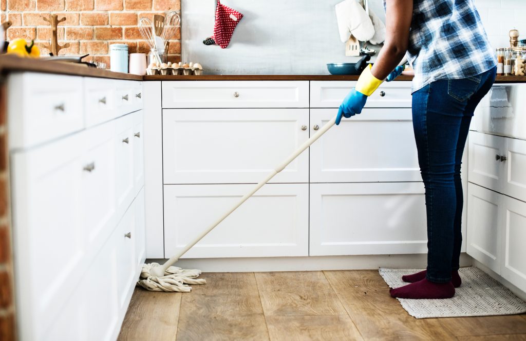 A person mopping the kitchen floors