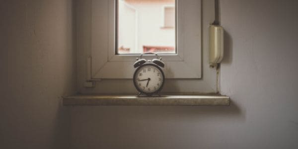 A small window featuring an old alarm clock 