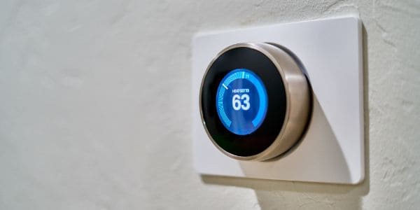 A smart thermostat on the wall showing 63