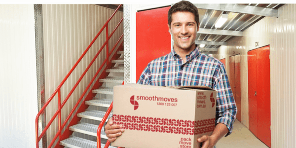 Middle aged man smiling while carrying a Smoothmove box 