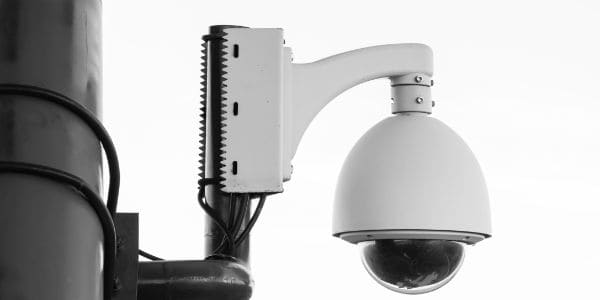 A white CCTV camera mounted on a wall 
