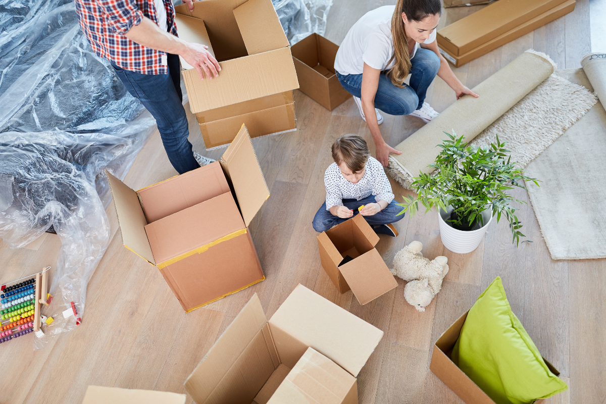 a family packing household items into various cardboard boxes