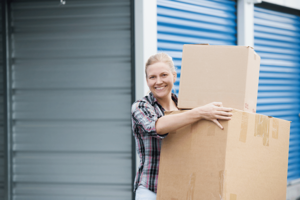 woman holding a few cardboard boxes to store in her storage unit