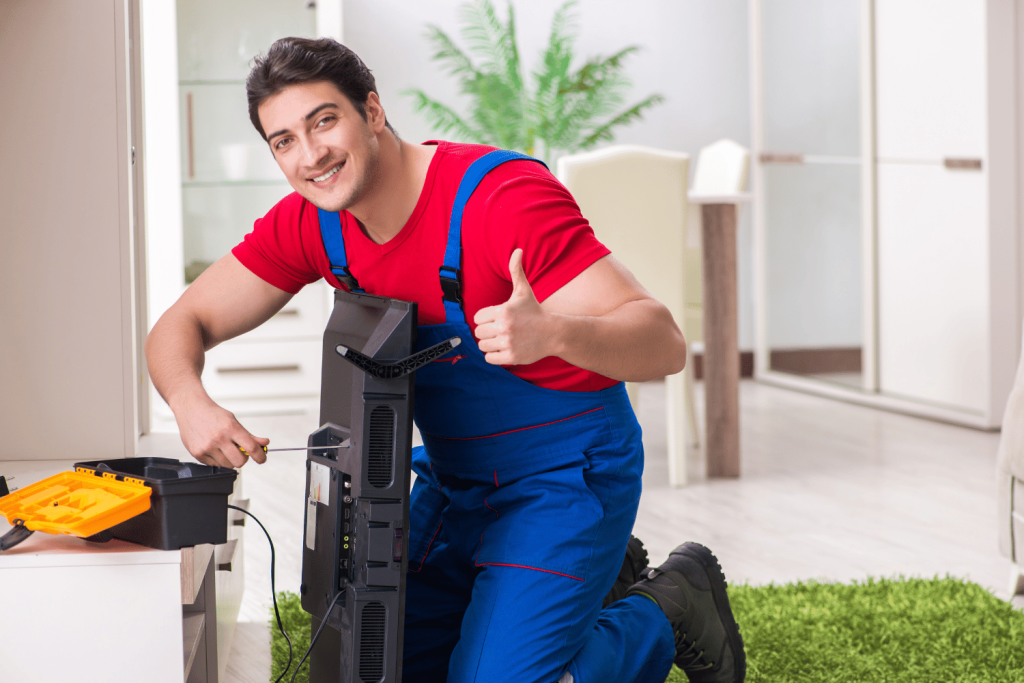 Removalist worker signing thumbs up while installing a TV